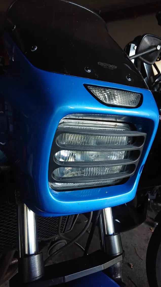 Une grille de phare imprimée en 3D et peinte en bleu, montée sur l’avant d’une moto